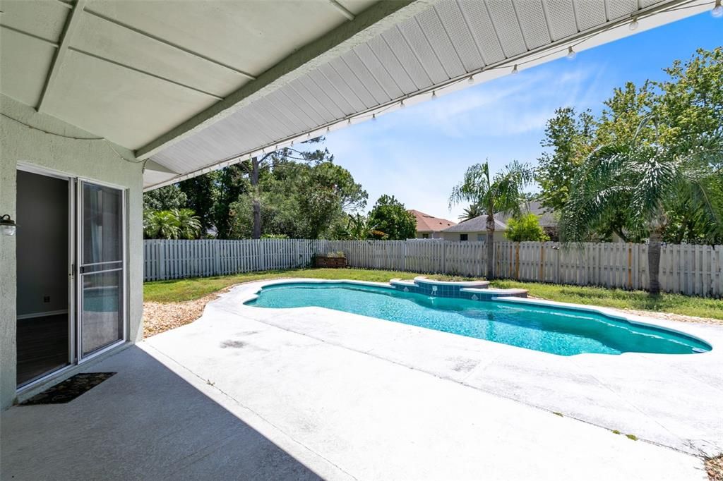 Step outside to the covered lanai and take in the view of the sparkling pool and fenced backyard.