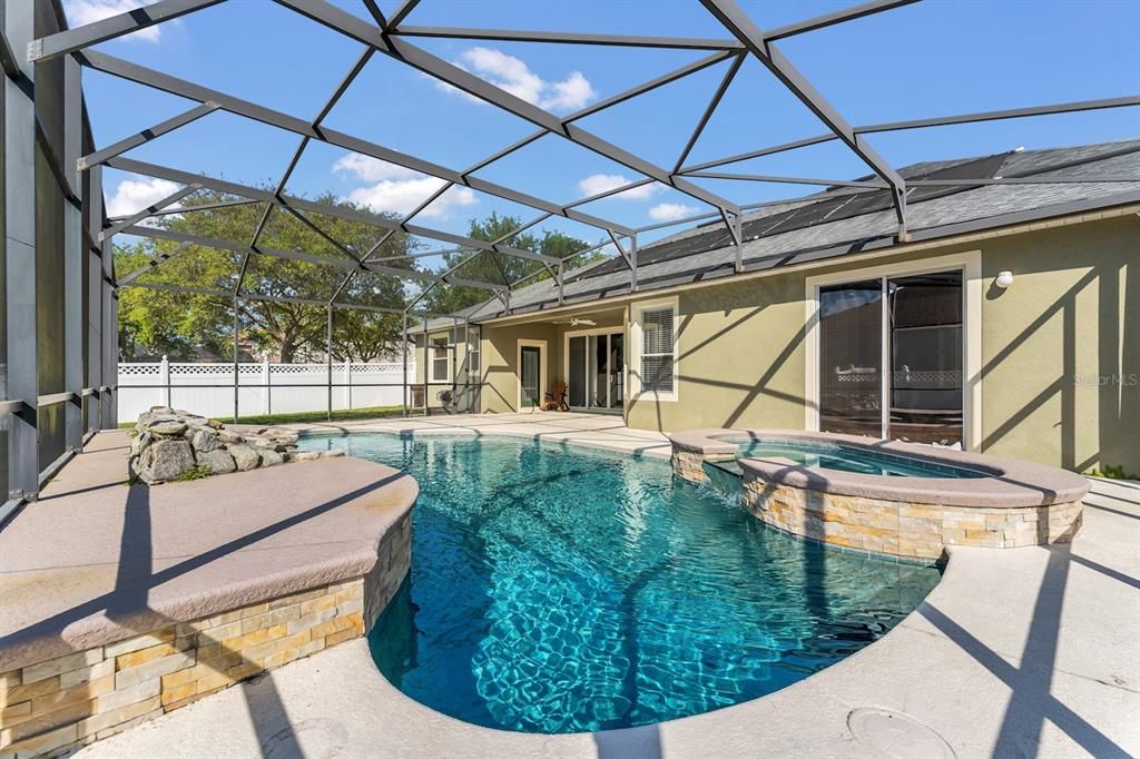 Large pool deck with a heated pool and spa for hot summer days