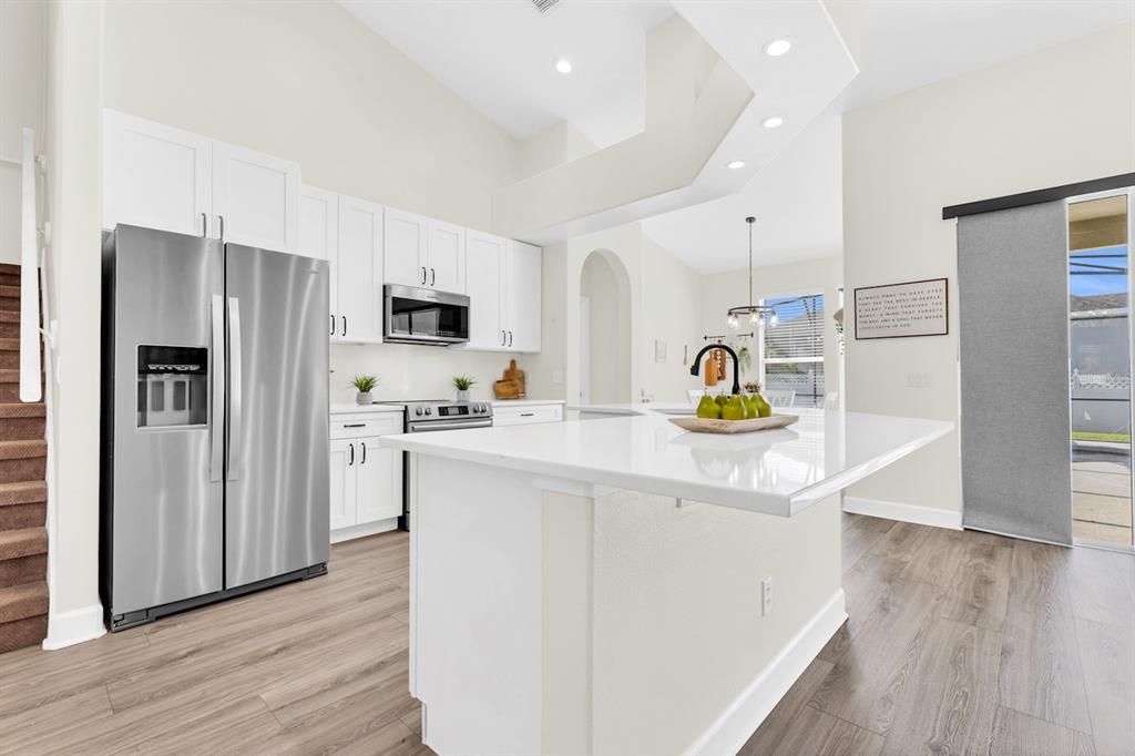 Upgraded kitchen boasts quartz countertops, full-height backsplash, and top-of-the-line appliances