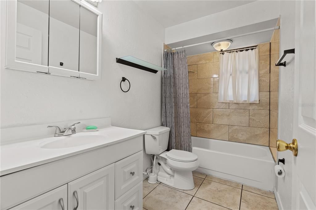 Renovated bathroom is located between bedrooms and main living area.