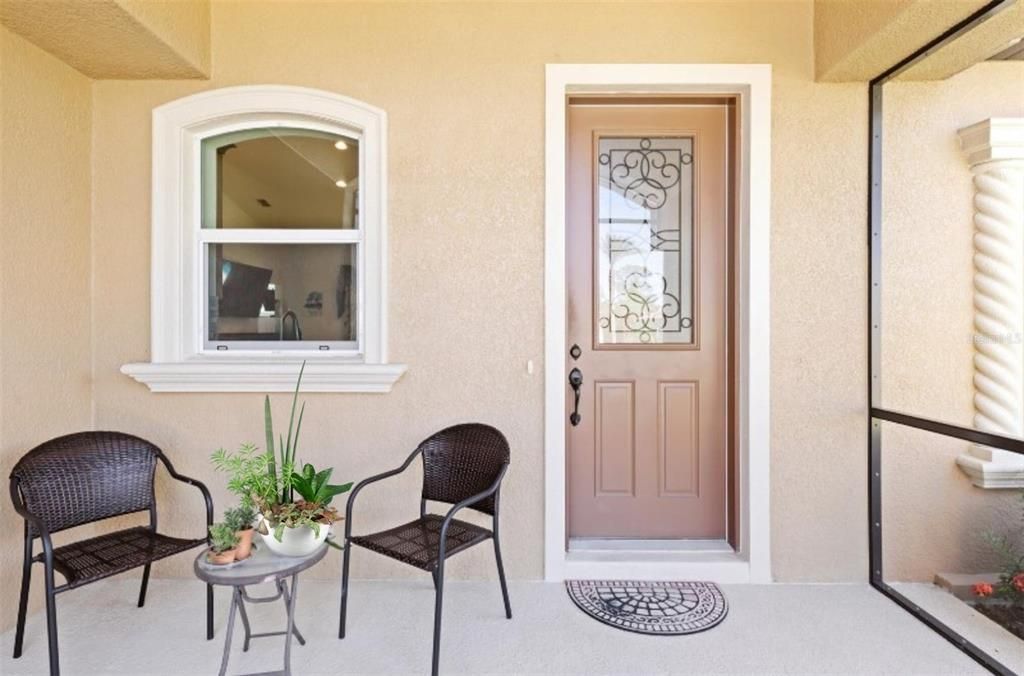 The enclosed, screened front entryway is an inviting space to welcome visitors to your custom-built home.