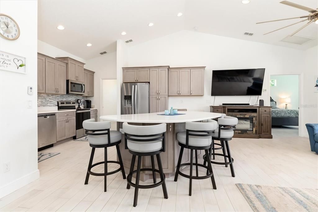 The open-concept floor plan provides easy access to everything, including the larger of the TWO PRIMARY ENSUITE BEDROOMS, which can be seen from this angle, as well as the entrance to the laundry room and garage.