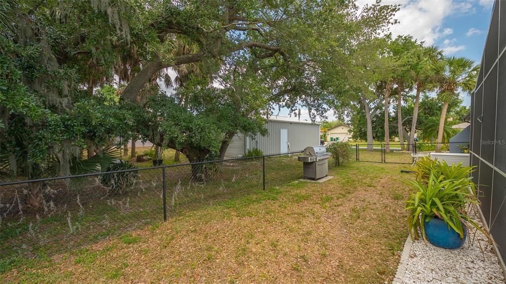 FENCED YARD AND SIDE VIEW OF OVERSIZED DETACHED GARAGE