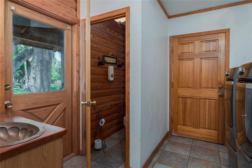 Half bath and laundry room with access to pool/porch