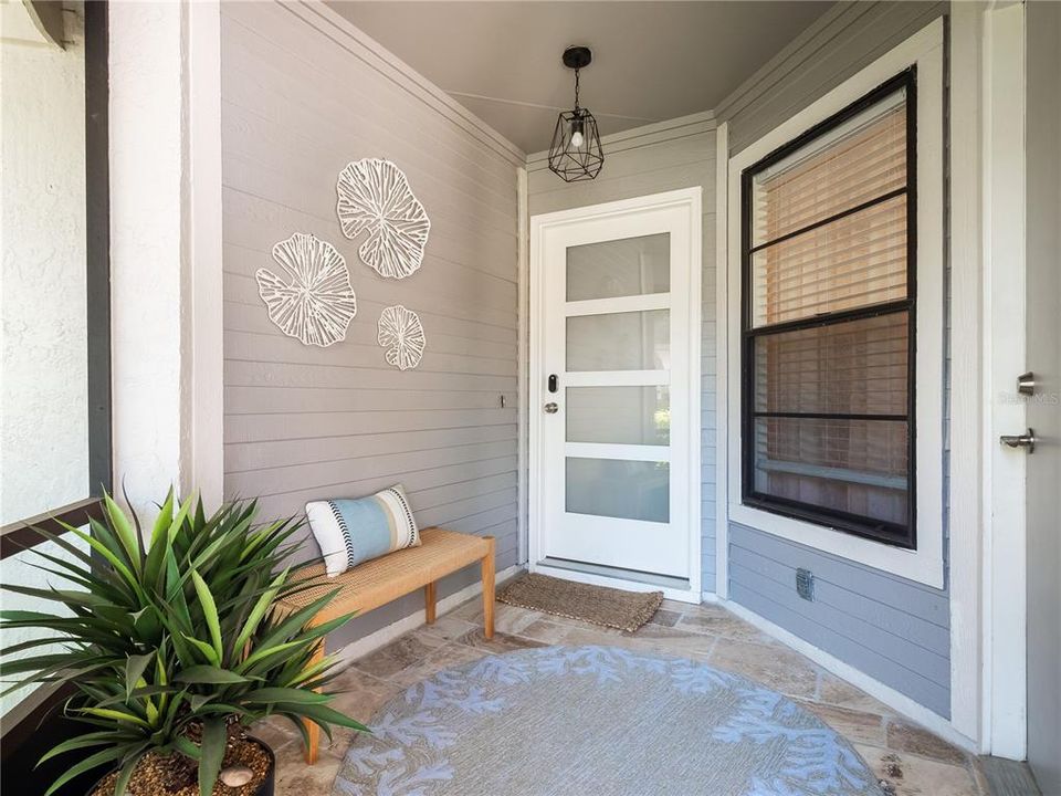 The welcoming enclosed porch has been updated iwth new exterior door and lighting.