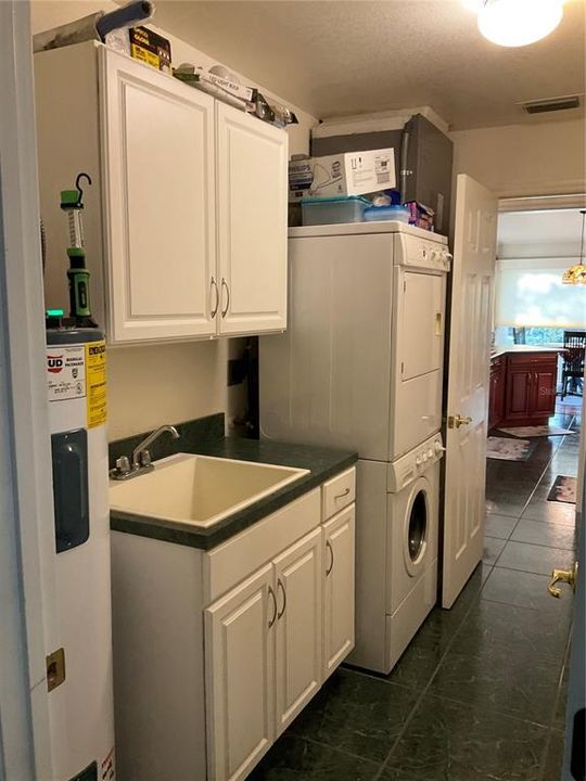Inside laundry room with cabinet storage and pantry. Second hot water heater