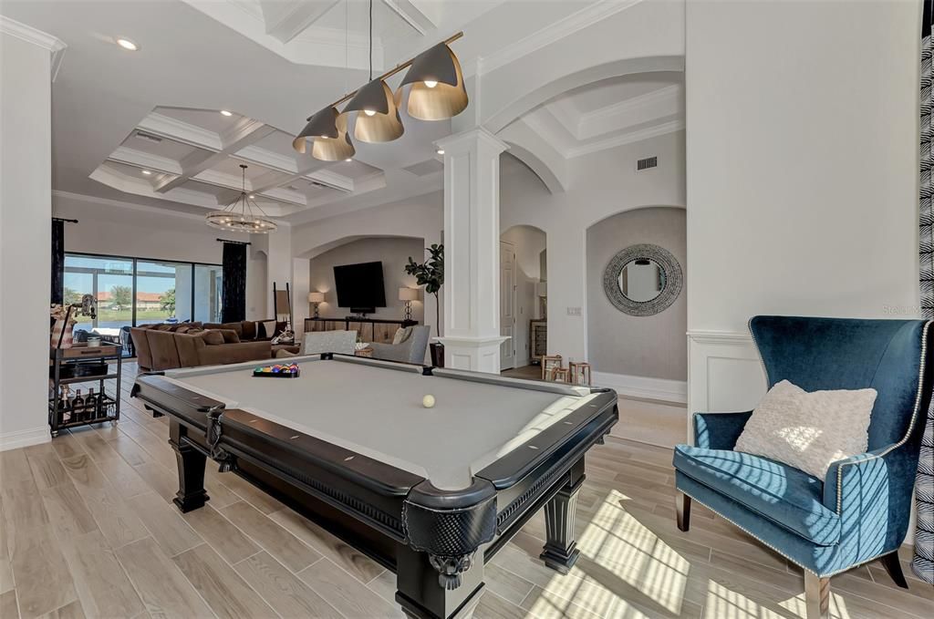 Wainscoting and a drink rail add dimension to the dining room/billiard room,