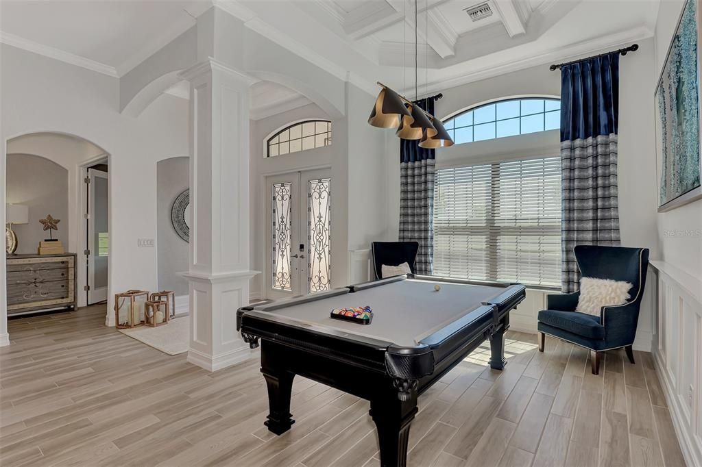 Wainscoting and a drink rail add dimension to the dining room/billiard room,