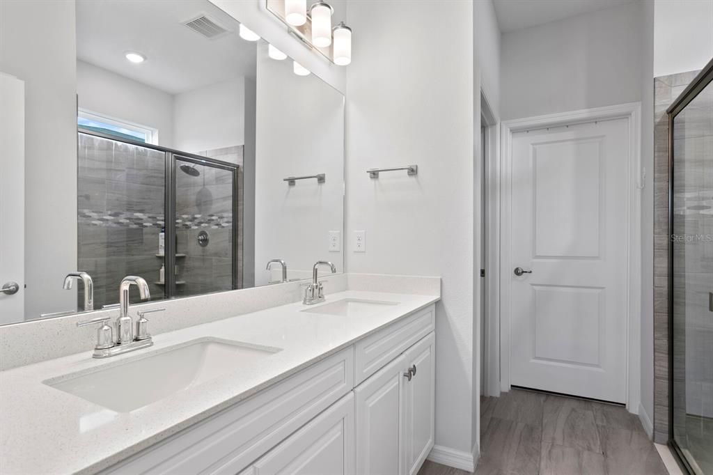 Bathroom features shower, dual sinks, and separate water closet.