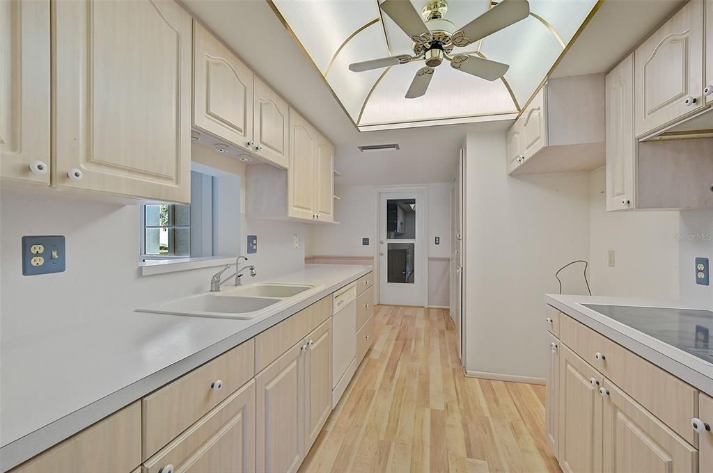 Kitchen is functional with ample cabinets!  See next photo, with Fridge and Microwave (new) that was just installed.   Older Washer/Dryer also installed and seem to work fine, but AS IS.  Door to the 2-car garage straight ahead.  Also a small dinette area is located towards the back of kitchen...  or could be a nice study/work area.