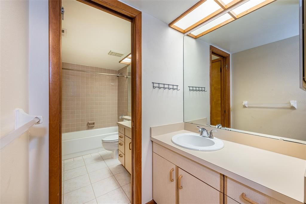 The primary bedroom has a private vanity with sink, and direct access to the shared full bath through a pocket door.