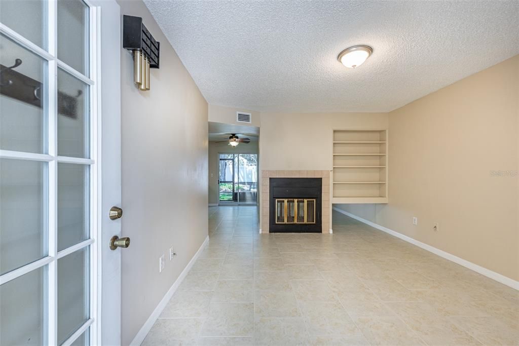 Inside, a spacious living room awaits, complete with a two-sided wood-burning fireplace adorned with built-in shelving, creating a cozy ambiance that's perfect for relaxing evenings.