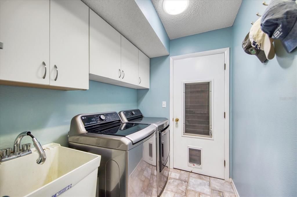 Laundry room with storage closet & cabinets + utility sink opens to garage~