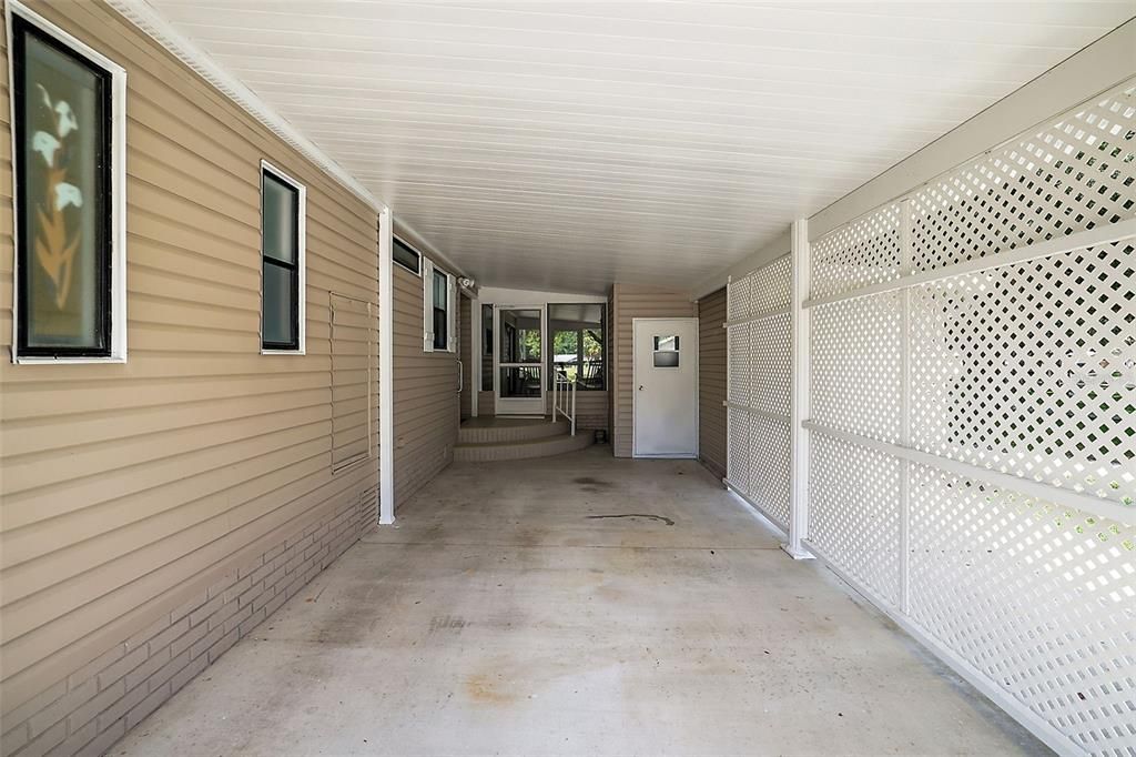 Spacious carport with door into golf cart garage/workshop. Also, a door to the screened lanai and interior.
