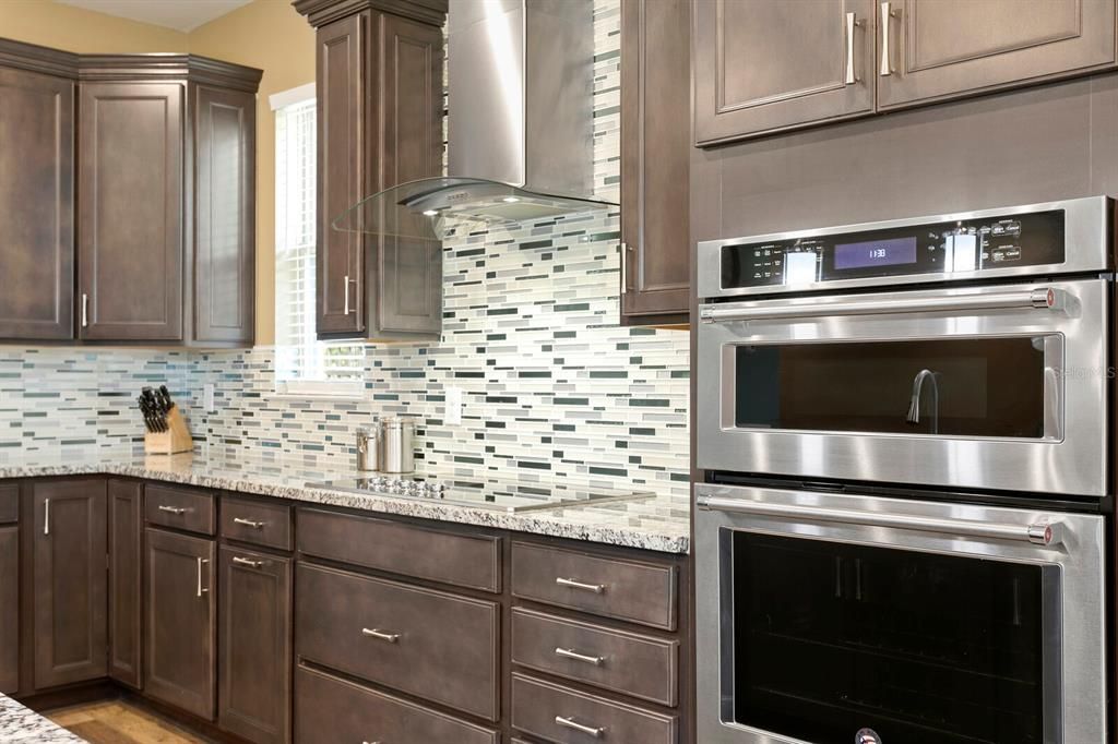 The kitchen includes an upgraded KitchenAid stainless appliance package, flat cooktop and vented hood