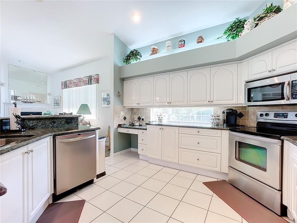 Spacious Kitchen. Stainless Steel appliances. Breakfast bar that seats 4. Plenty of cabinetry with desk areaand glass block for bringing in natural light and decorator shelves.
