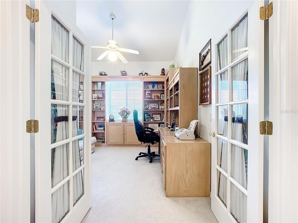 French Doors leading to bedroom w/closet with custom built desk used as office.