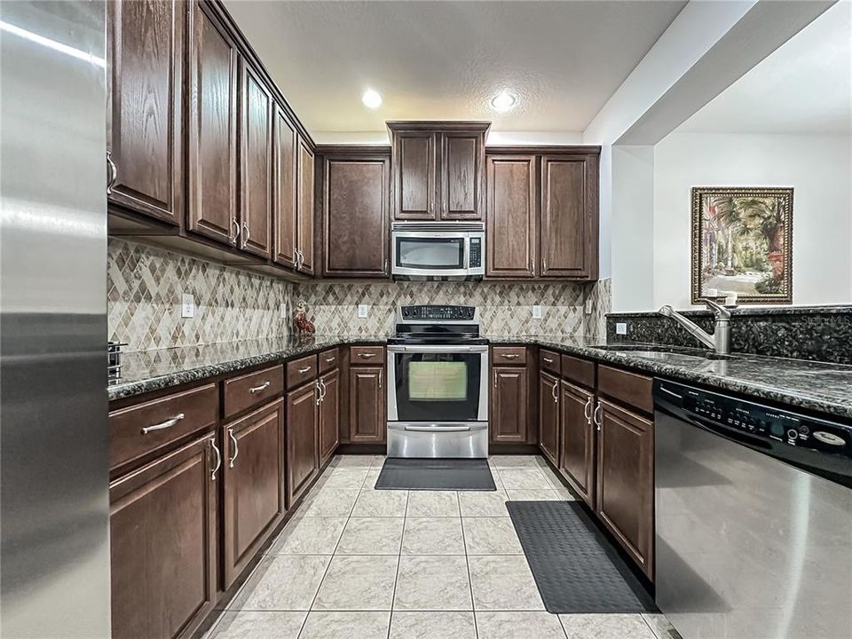 Enjoy the spacious kitchen with lots of countertop space, 42-inch cabinets, granite countertops, custom backsplash and stainless steel appliances.