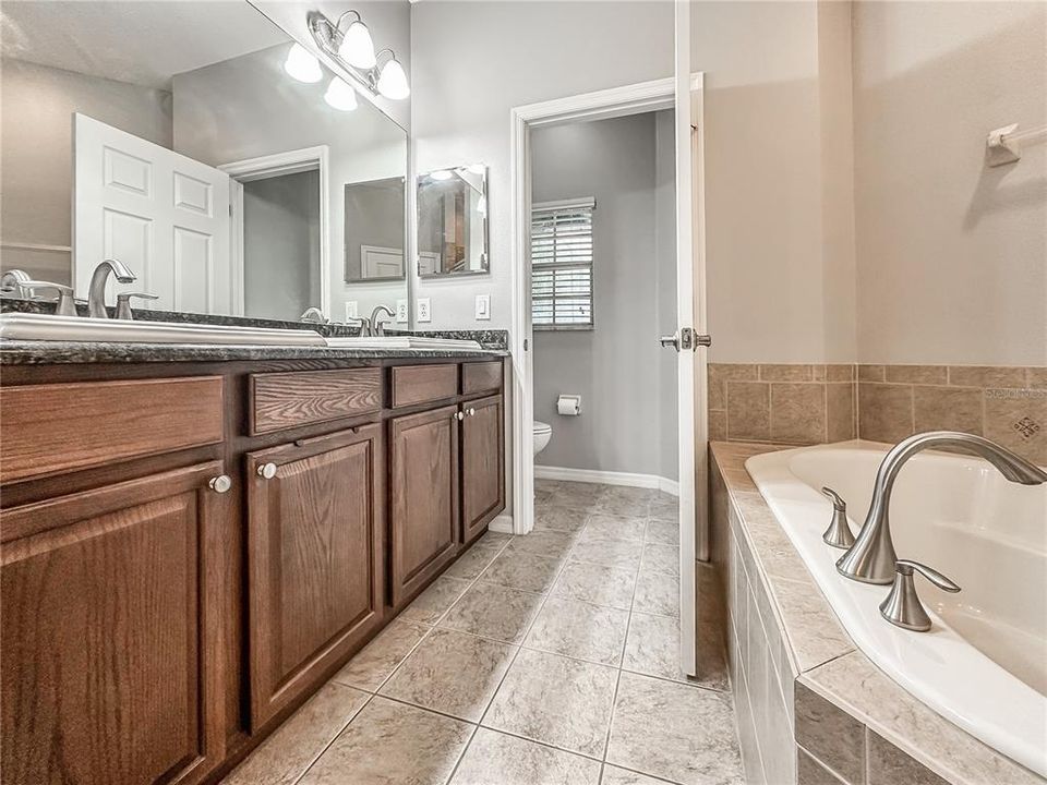 The owner's bath features granite countertops, his and hers sinks, shower, soaking tub, and water closet.