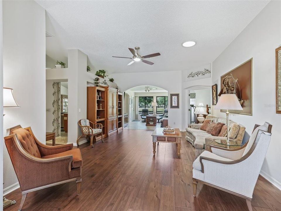 Living Room featuring high ceilings, laminate wood floors and open to the bright and airy family room