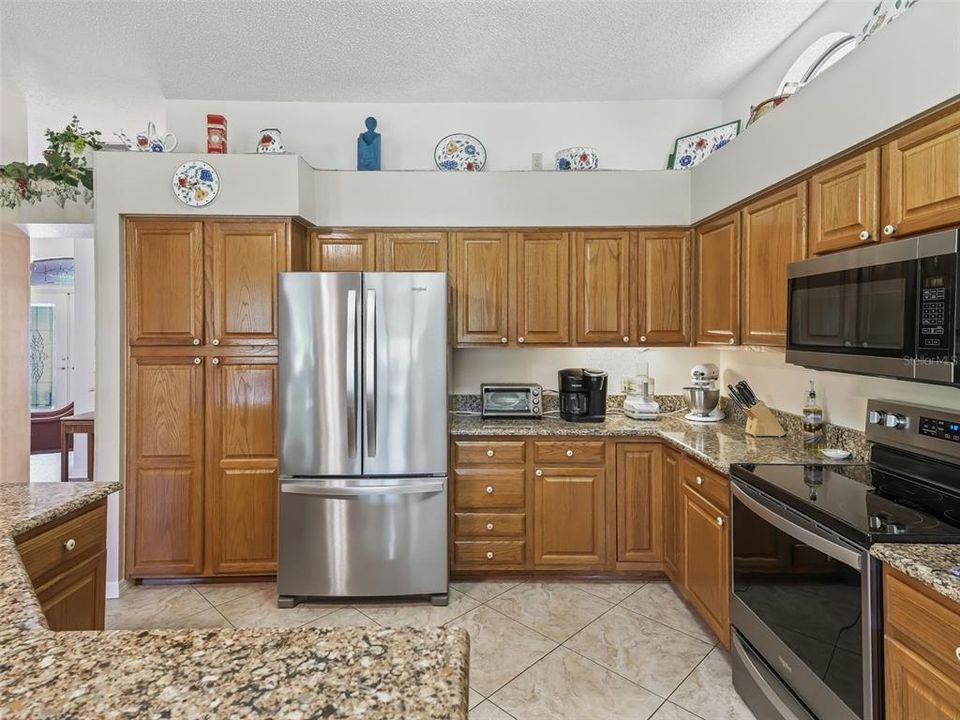 Open Kitchen featuring a large Island, Solid Wood Cabinetry, Quartz Countertops and Stainless Steel Appliances