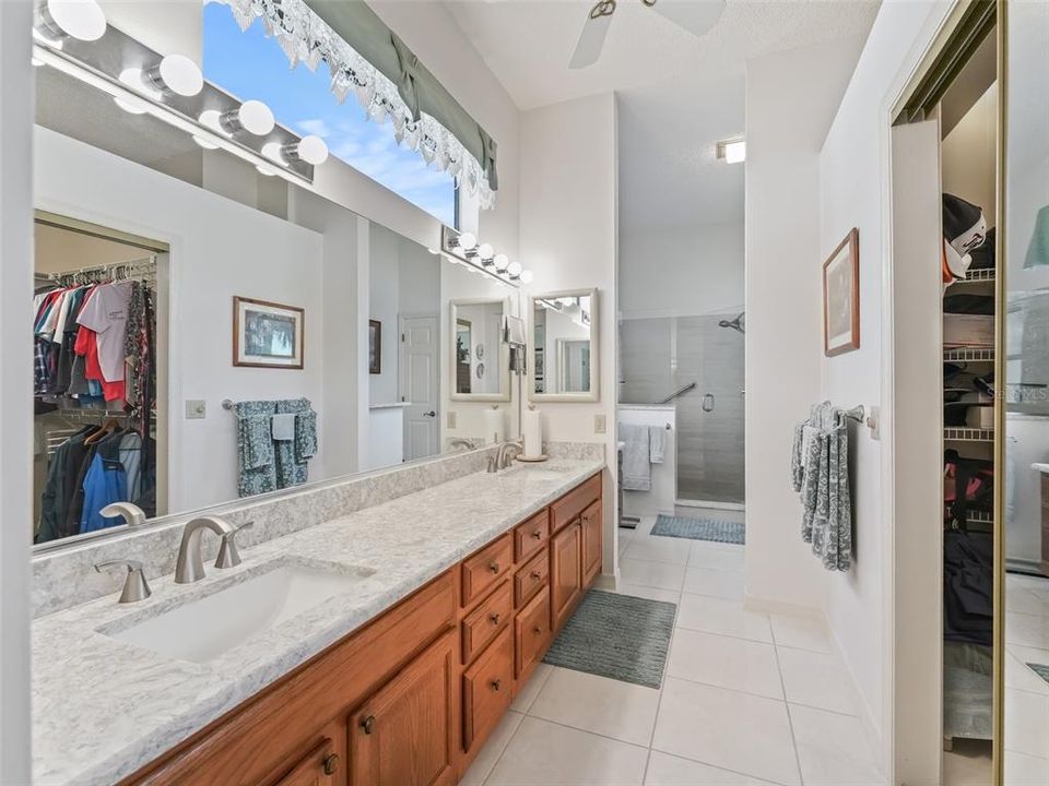 Primary Bath featuring a Custom Tiled Walk-in Shower with Frameless Glass Doors and Dual Vanity with Quartz Countertops.