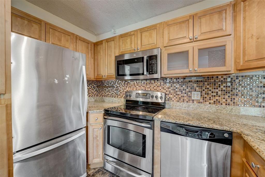 BEAUTIFUL KITCHEN WITH GRANITE COUNTERTOPS, STAINLESS STEEL APPLIANCES, UPGRADED CABINETS, TILE BACKSPLASH AND SUNKEN SINK!