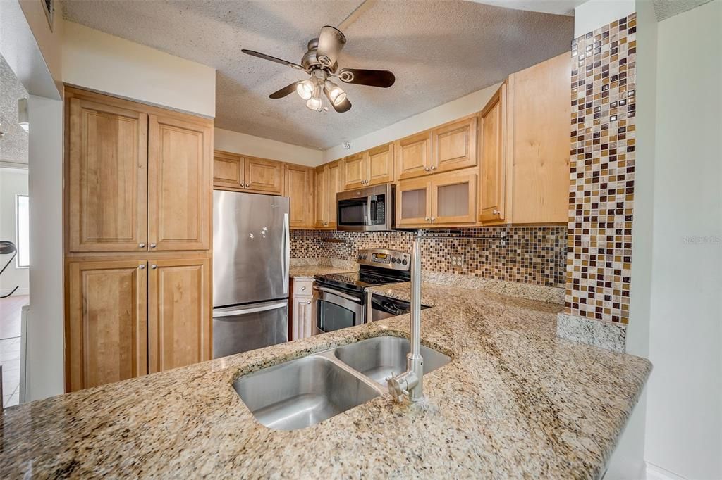 BEAUTIFUL KITCHEN WITH GRANITE COUNTERTOPS, STAINLESS STEEL APPLIANCES, UPGRADED CABINETS, TILE BACKSPLASH AND SUNKEN SINK!