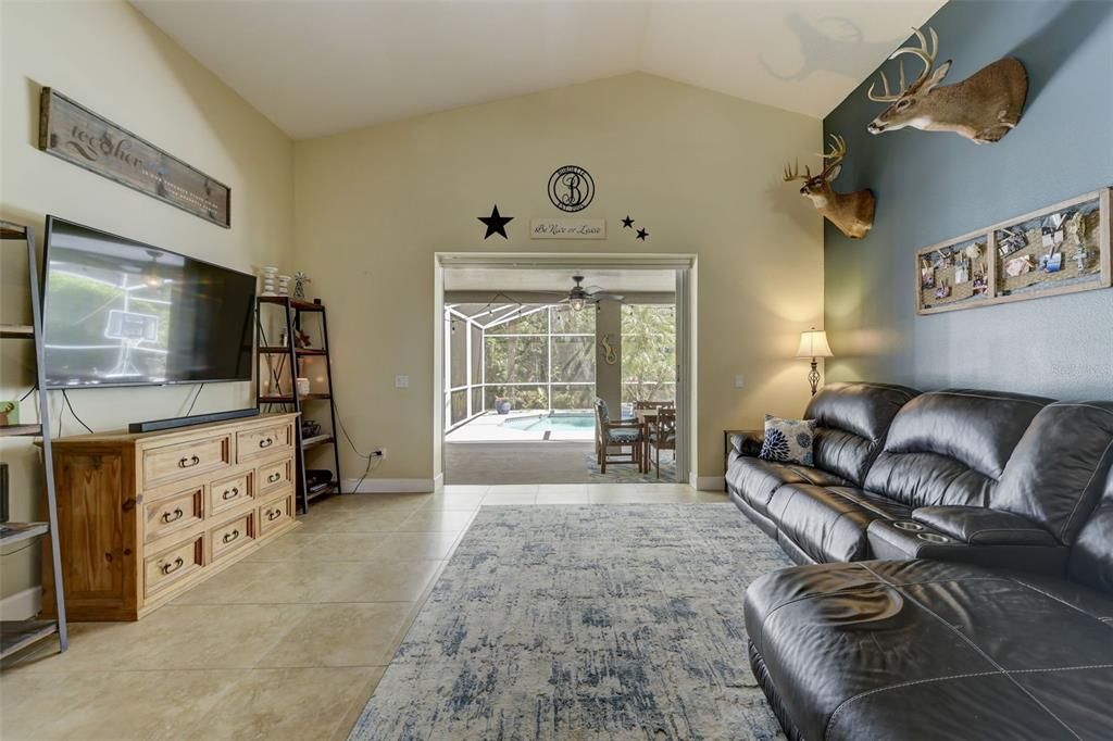 LARGE FAMILY ROOM - OPEN FLOOR PLAN. TRIPLE SLIDERS LEAD OUT TO THE POOL AREA