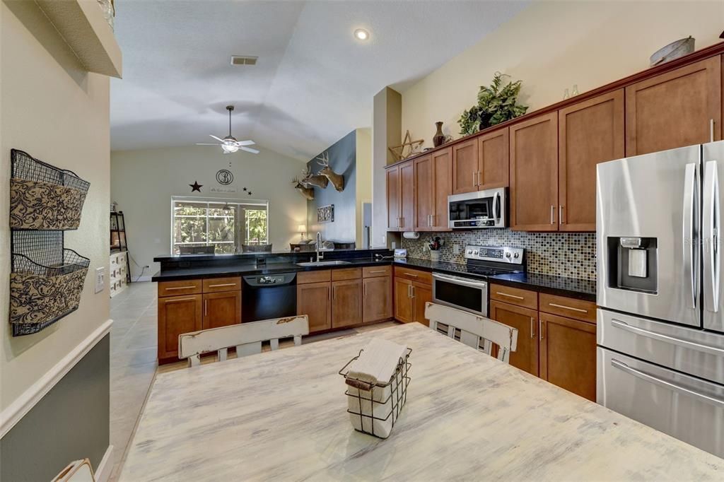 UPDATED KITCHEN with GRANITE COUNTERTOPS, STAINLESS STEEL APPLIANCES, TILE BACKSPLASH and UPGRADED CABINETS