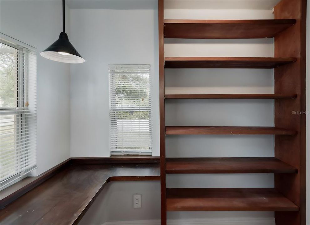 Record room or library with built-in wooden shelves & two built-in desks.