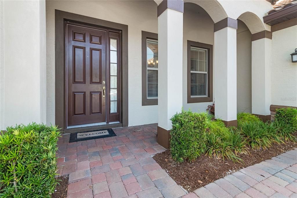 Paver driveway leads to covered entry