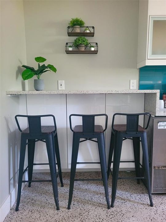 Additional barstool seating can be found in the kitchen area