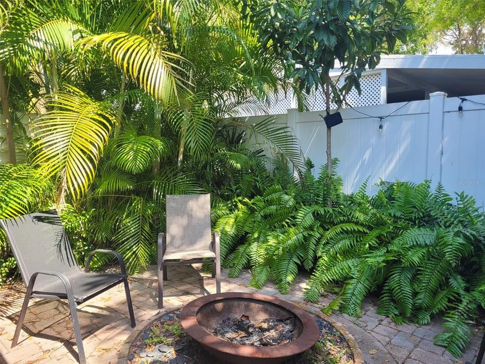 Private porch area with fire pit. From this area there is a gate to the backyard and also to the front yard / driveway area