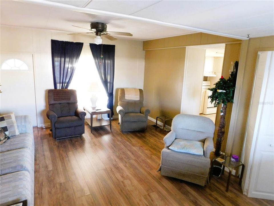 Living room has laminate flooring, ceiling fan, and is opens to bonus room.
