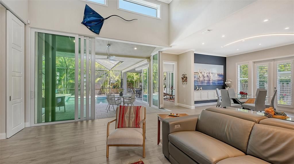 Soaring 18-foot ceilings adorned with a wall of expansive 10-foot sliders beckon you towards a sprawling outdoor oasis, perfect for entertaining