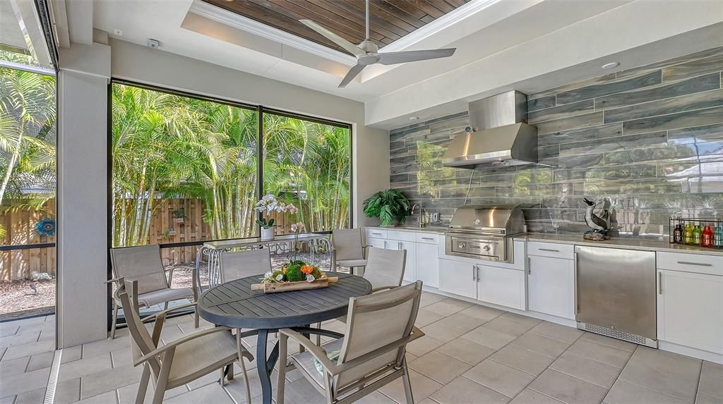 Step outside to discover a sprawling lanai adorned with a resort-style heated pool and spa and an impressive summer kitchen, enveloped by lush landscaping and illuminated by landscape lighting