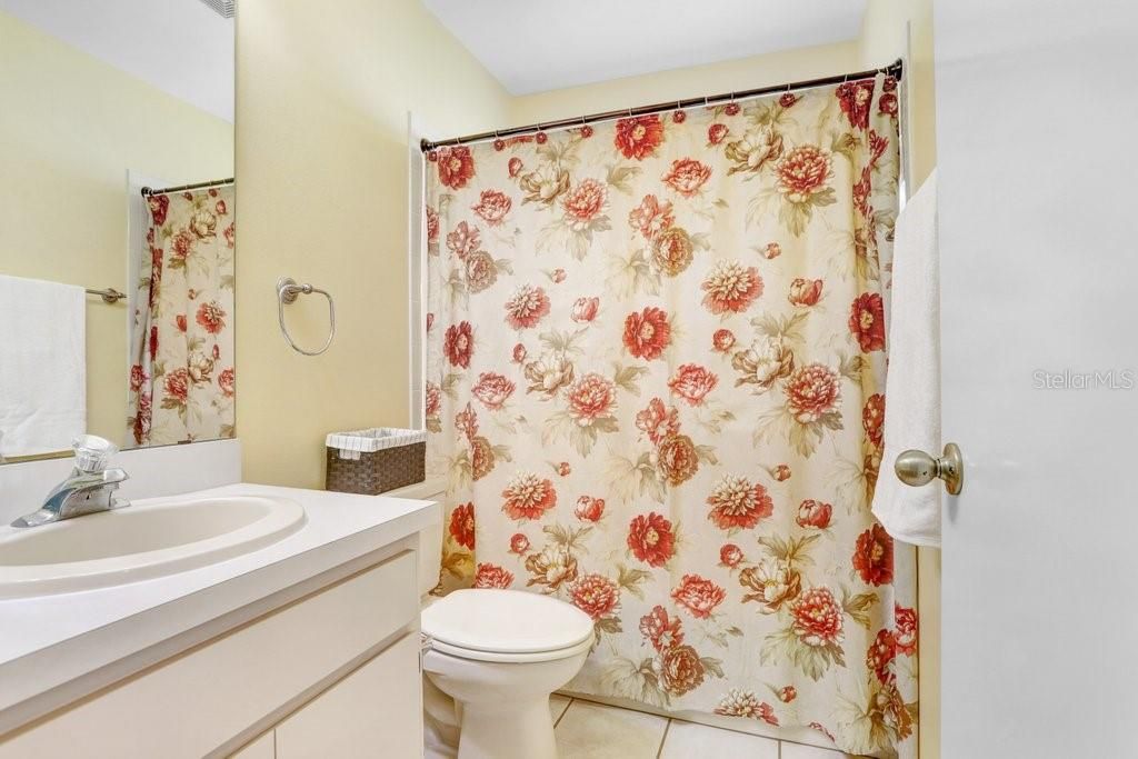 Bathroom 2 features ceramic tile flooring, a tub/shower combo with tile, and two towel bars.