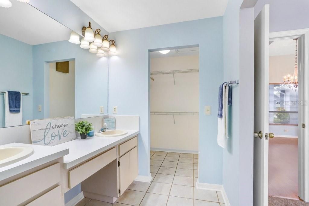 The master ensuite features a walk-in closet, dual sinks, lots of storage cabinets, a linen closet, ceramic tile flooring, a door to the toilet/shower area, and a garden tub/shower combo.