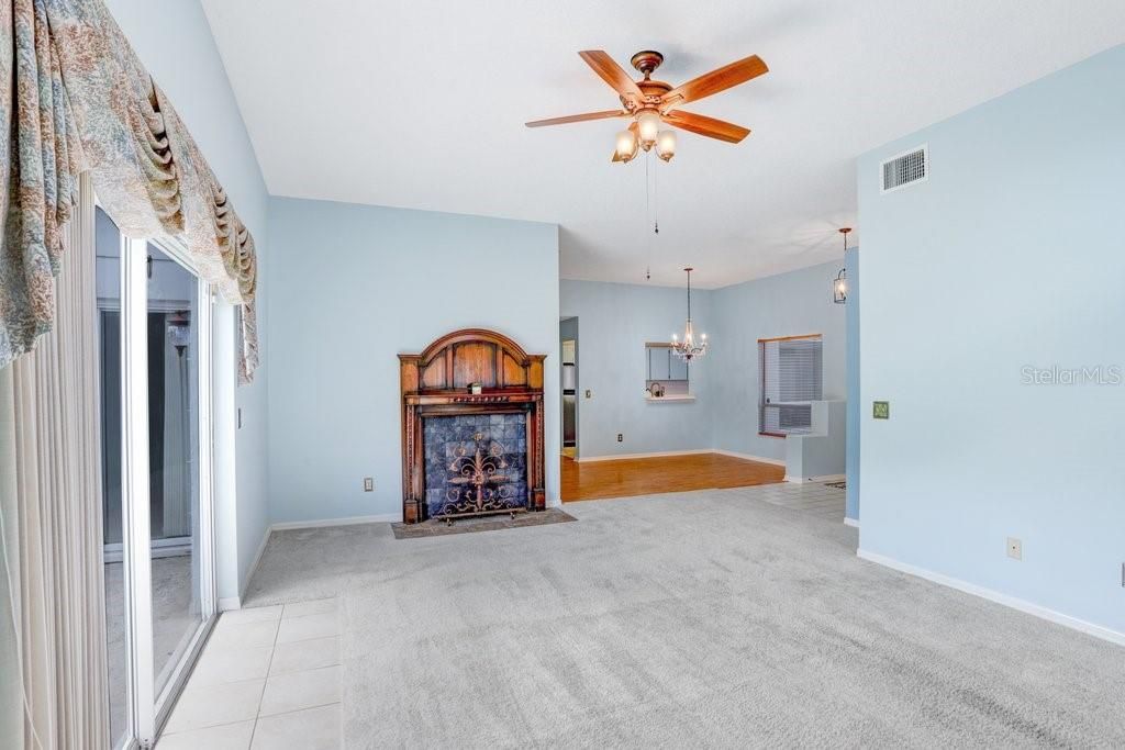 Inside you'll find an open floorplan, a decorative fireplace that will stay, a beautiful chandelier in the dining room, a large sliding glass door to the backyard, a lighted ceiling fan, and lots of natural light!