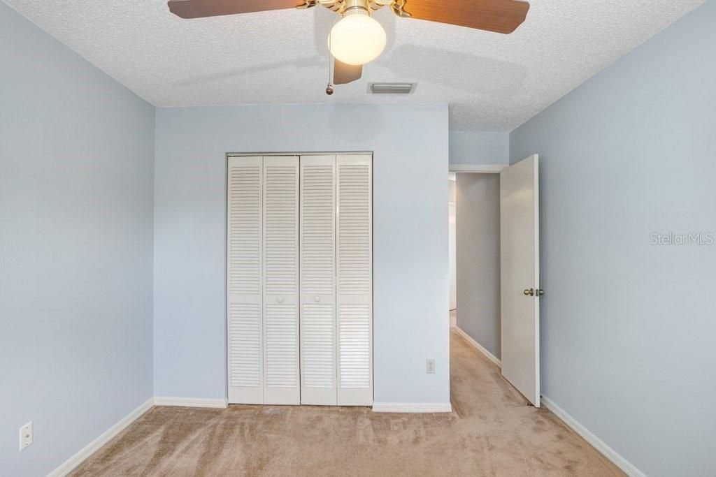 The second bedroom has an adorable window space to sit in or to display some of your favorite plants or collections.  It also features a lighted ceiling fan and a good-sized closet.