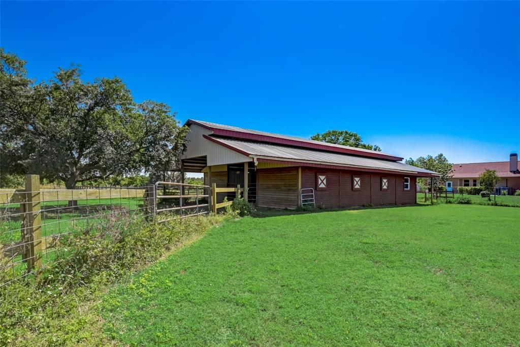 Horse barn leads to fenced fields