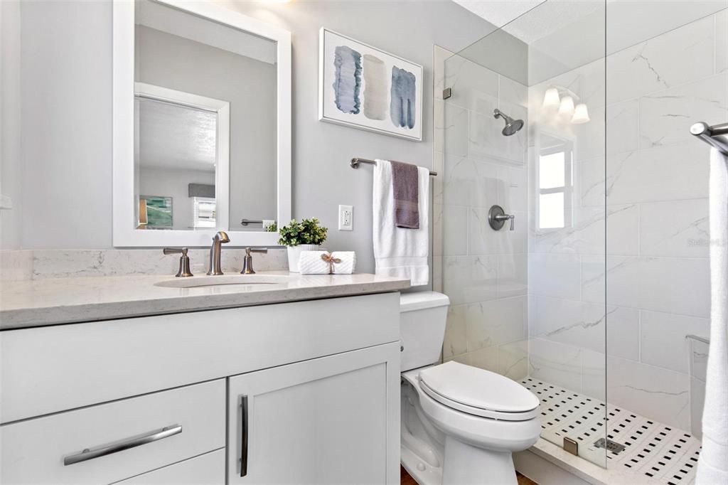 Primary bathroom has updated shower, quartz countertops and you'll appreciate some extra space on the counters for necessary items.