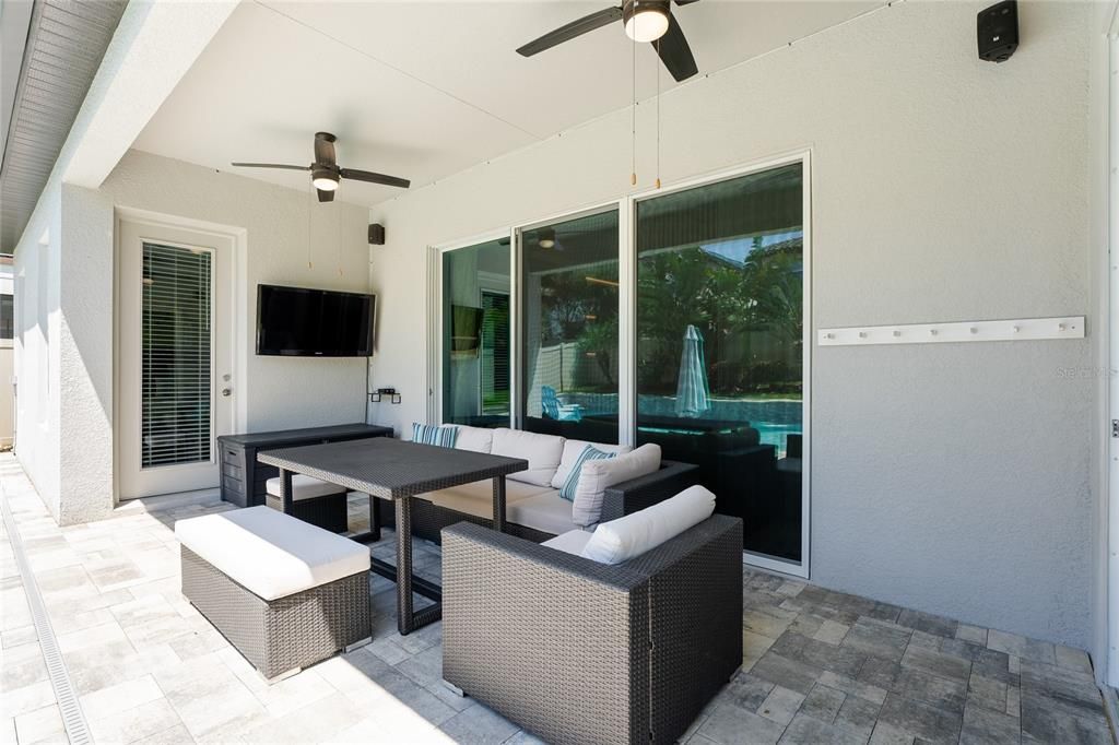 Pool side lanai with pavers and a mounted TV.