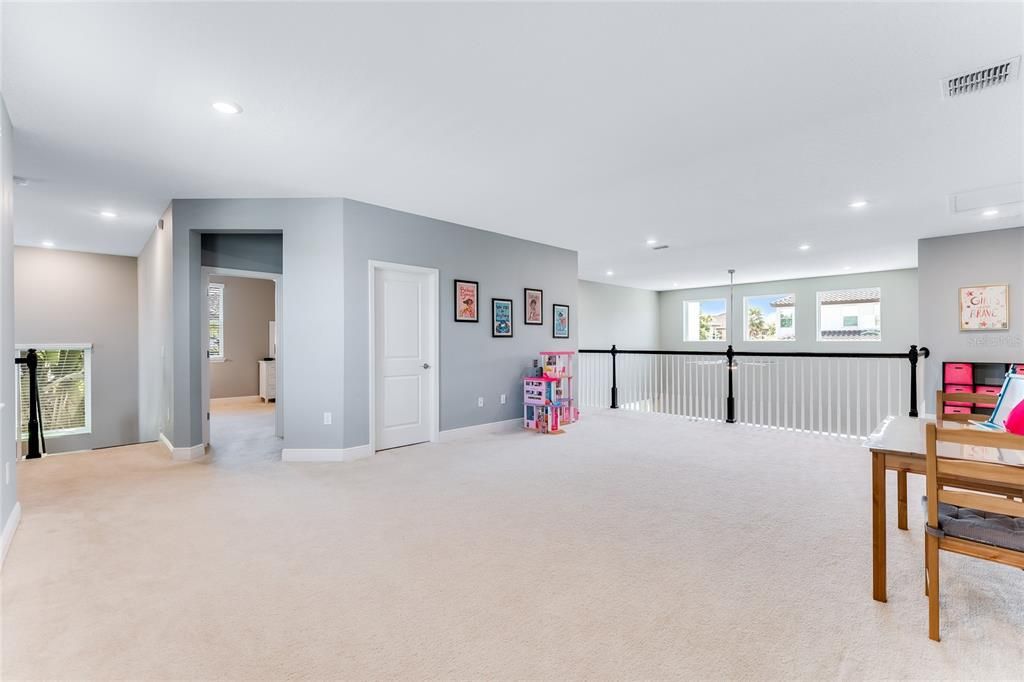 The expansive bonus room/loft in the center of the second story overlooks the two-story family room below.