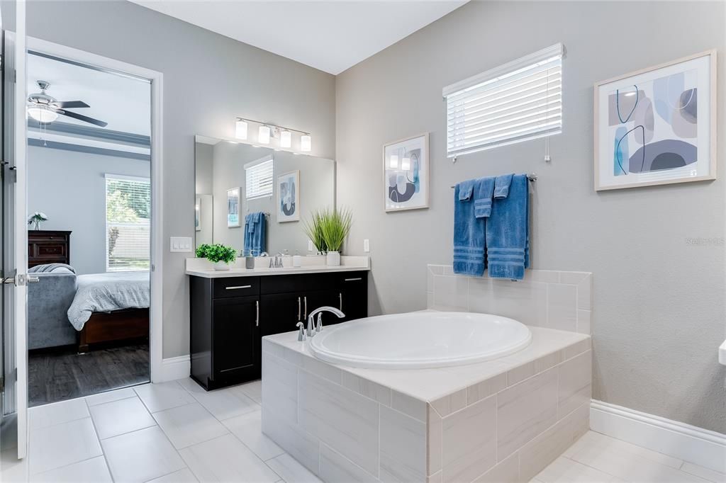 The soft grey walls and white tile floors give a crisp clean look to this stunning master bath.