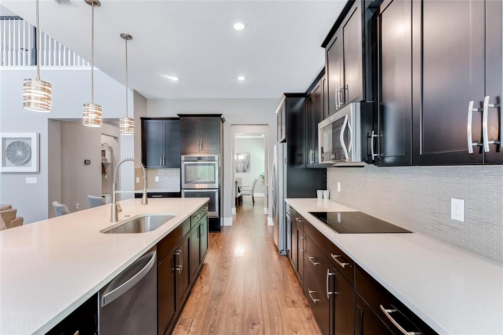 the gourmet kitchen has spacious counters, double wall ovens, microwave oven above the cooktop, large single farmhouse type sink and an abundance of cabinets and counter space.