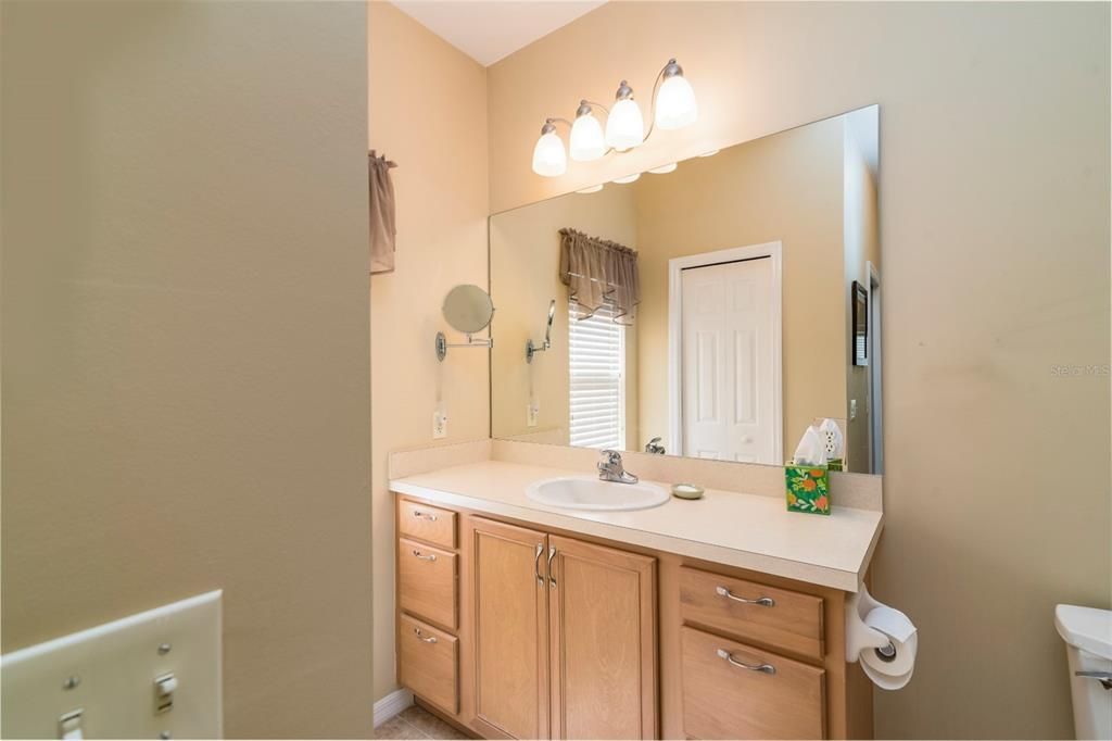 The master bath has an elevated vanity with drawers and upgraded lighting fixture.