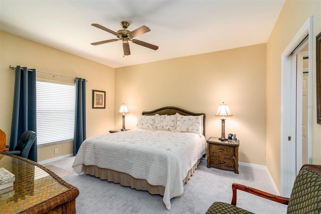 The large master bedroom has newer carpeting, ceiling fan, and a pocket door that can isolate the bedroom from the bath.