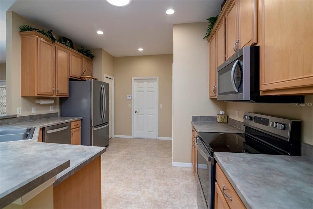 The chef friendly kitchen features newer stainless steel appliances that include a French door refrigerator, light oak cabinetry with pulls, 42 inch uppers, and crown molding.